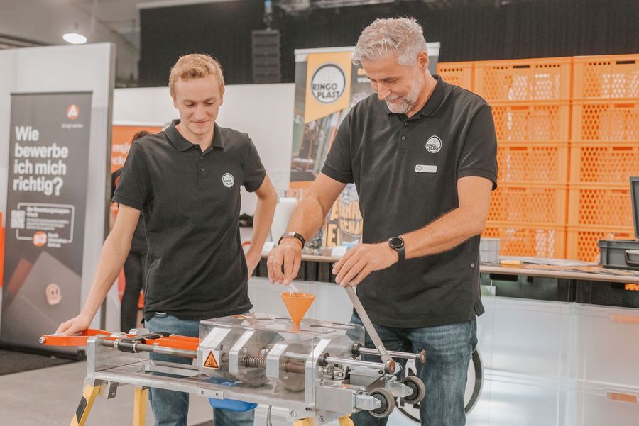 Zwei Mitarbeiter demonstrieren an einem Messestand eine technische Anlage auf der Arbeitswelten in Nordhorn