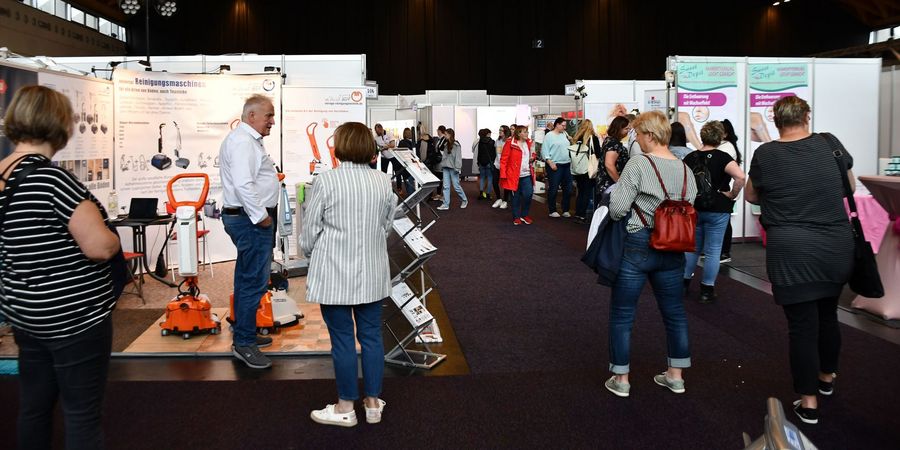 Besucherinnen und Besucher in einer Messehalle der PflegeMesse in Rostock