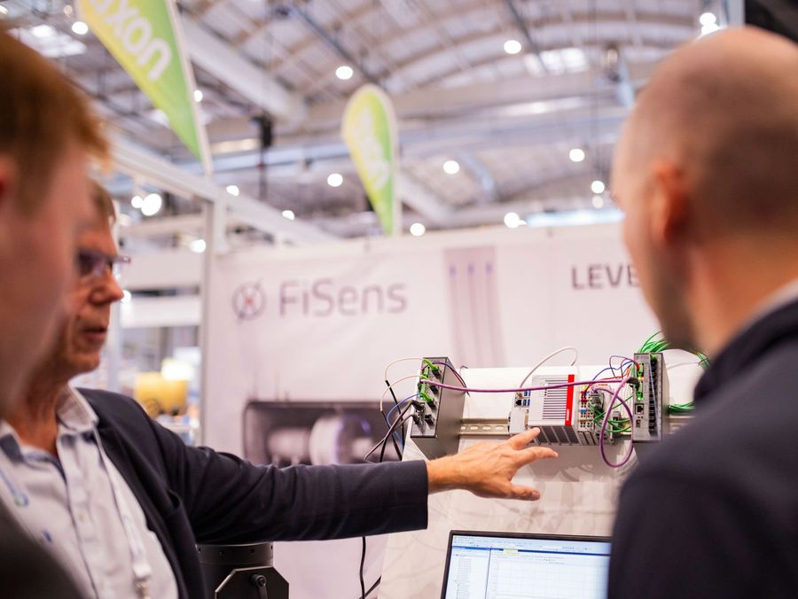 Fachbesucher lassen sich digitale Steuerungs- und Netzwerktechnik auf der WindEnergy Hamburg erklären
