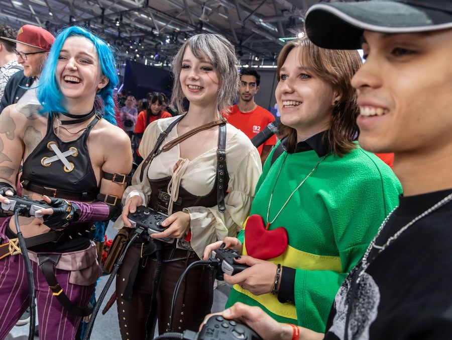 Gaming und Cosplay auf der gamescom in Köln Kostümierte Besucher spielen gemeinsam an Controllern auf der gamescom in Köln