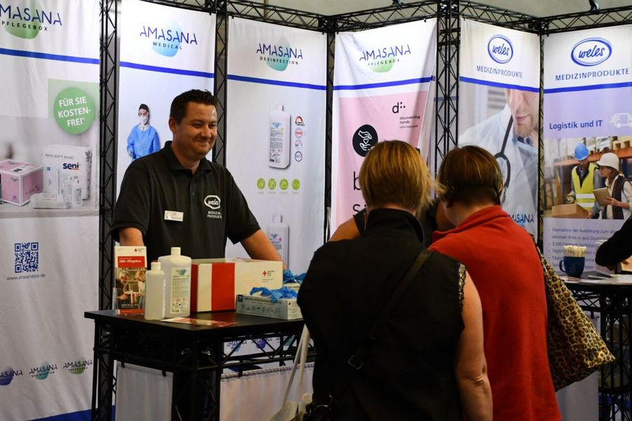 Besucherinnen informieren sich an einem Messestand über Pflege- und Medizinprodukte auf der PflegeMesse in Rostock