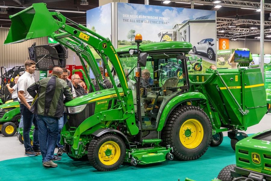 Fachbesucher begutachten einen kompakten Traktor mit Anbaugeräten auf der GaLaBau in Nürnberg
