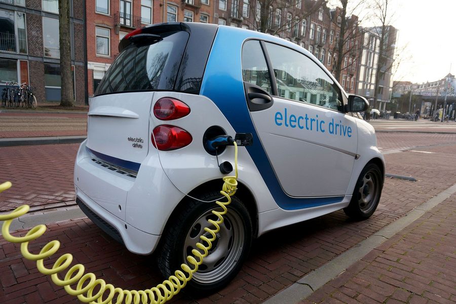 Elektroauto beim Laden Elektroauto beim Ladevorgang mit angeschlossenem Ladekabel in einer Stadt