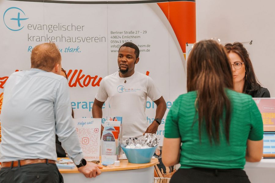 Besucher im Gespräch an einem Stand des Evangelischen Krankenhausvereins auf der Arbeitswelten in Nordhorn