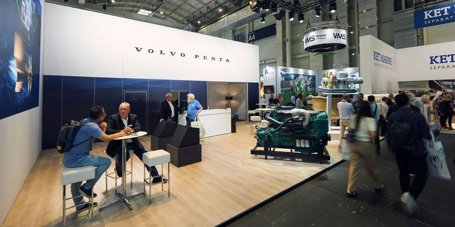 Fachbesucher an einem Stand mit Schiffsmotor auf der SMM in Hamburg