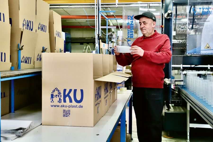 Qualität aus Tradition: Ein Mitarbeiter der AKU GmbH & Co. KG kontrolliert sorgfältig die Mehrwegbecher vor der Verpackung